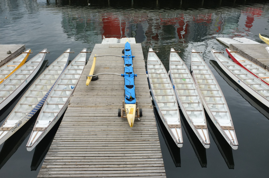 a dock and several dragon boats lined up and empty
