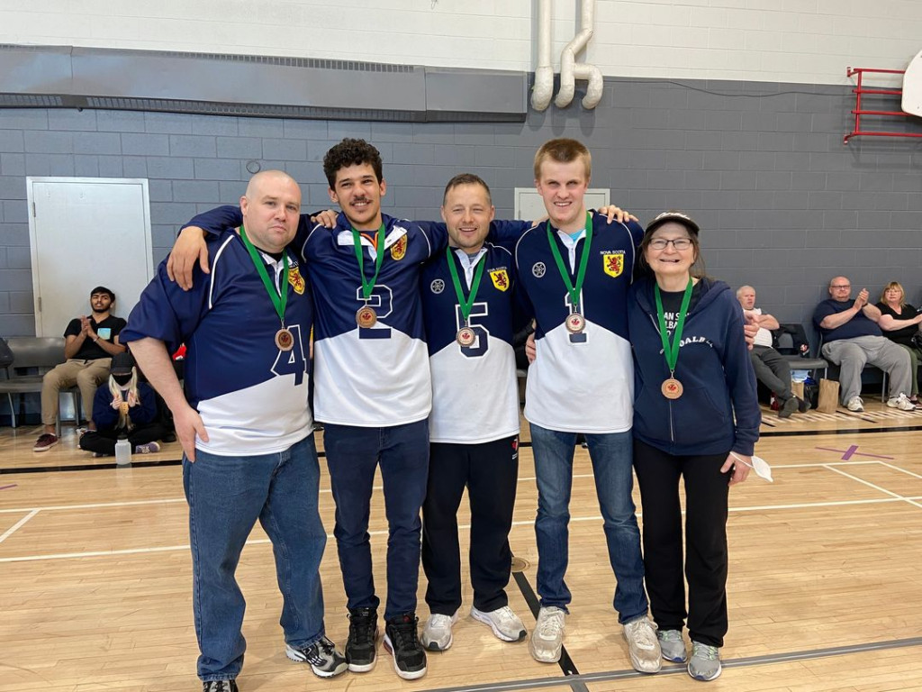 team pictured with bronze medals. From left to right - #4 Mike Grant, #2 Mason Smith, #5 Peter Parsons, #1 Nick Gentleman, coach Linda MacRae Triff.